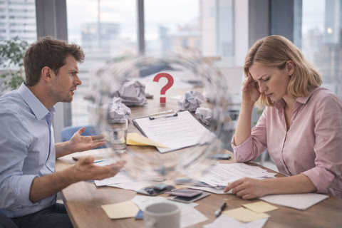 Мужчина и женщина за рабочим столом в момент напряжённого обсуждения